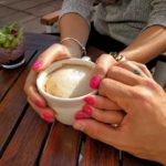 Couple holding hands and a cup of coffee