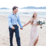 Couple running on beach after wedding