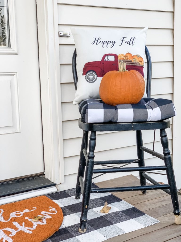 Chair with pillow and pumpkin on porch