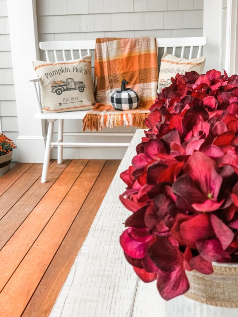 Floral table arrangement and a bench decorated for fall