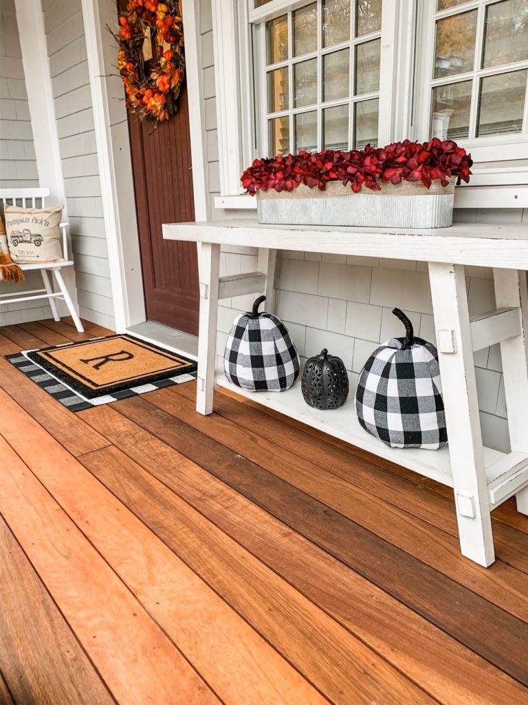 Console table on front porch with fall decor