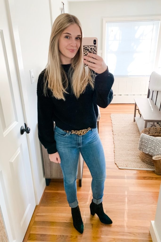 girl with a black sweater, leopard belt, jeans and black boots