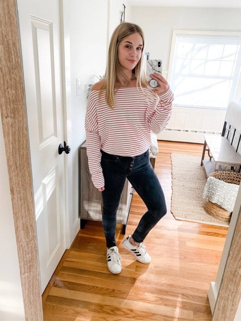 girl in red and white striped oversized long sleeve shirt, black jeans and adidas
