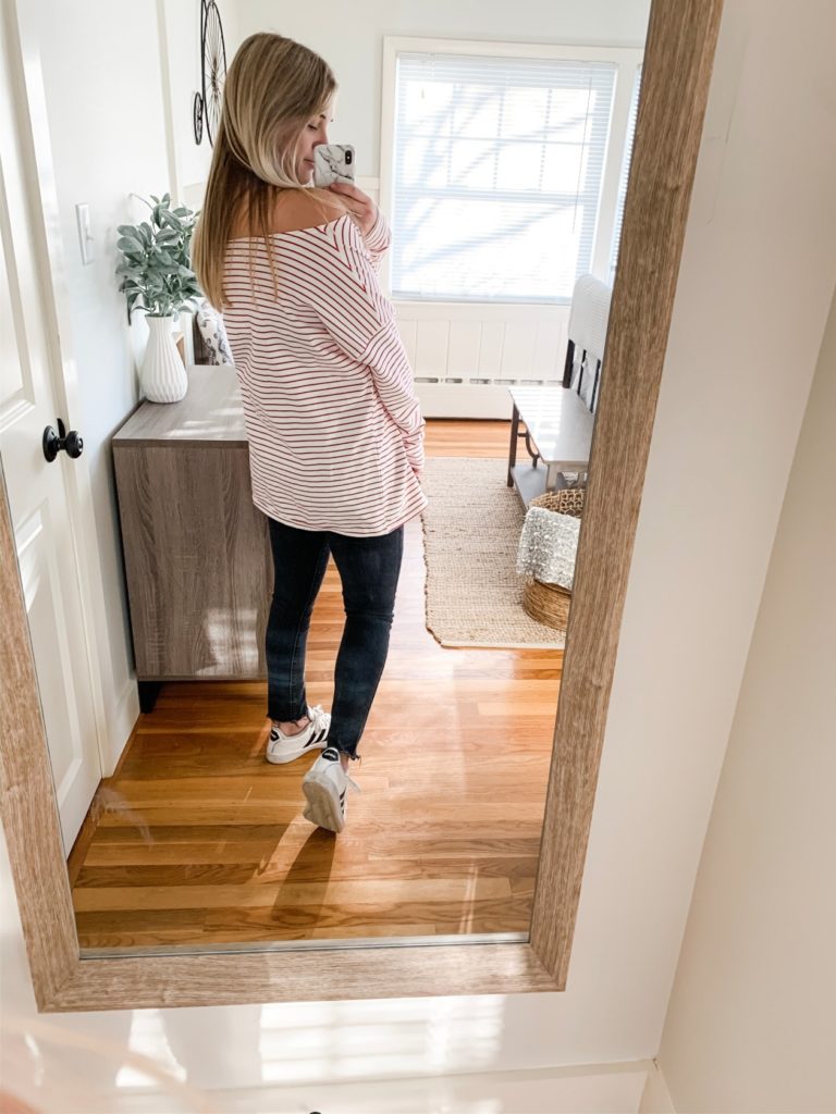 girl in red and white striped oversized long sleeve shirt, black jeans and adidas