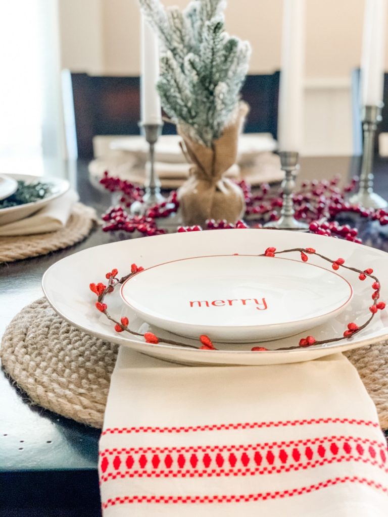 Christmas table setting. christmas place setting, christmas tablescape with candles, berries, and trees