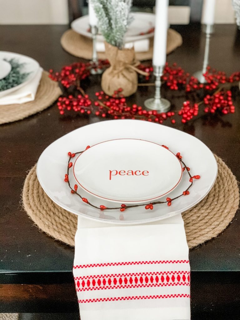 Christmas table setting. christmas place setting, christmas tablescape with candles, berries, and trees