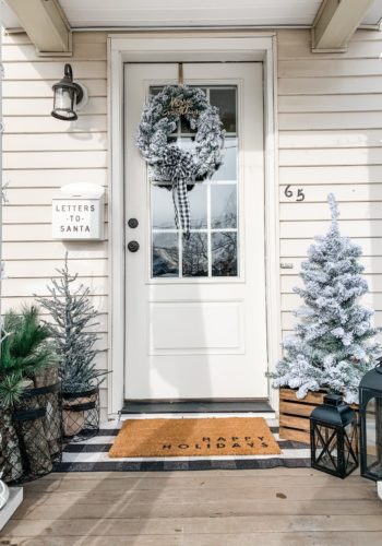 Farmhouse Winter Porch with Flocked Trees, logs, and metal baskets