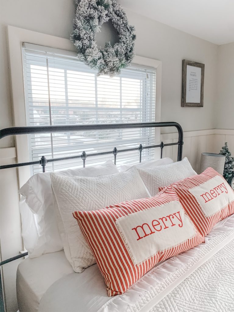 Christmas bed pillows and wreath above bed