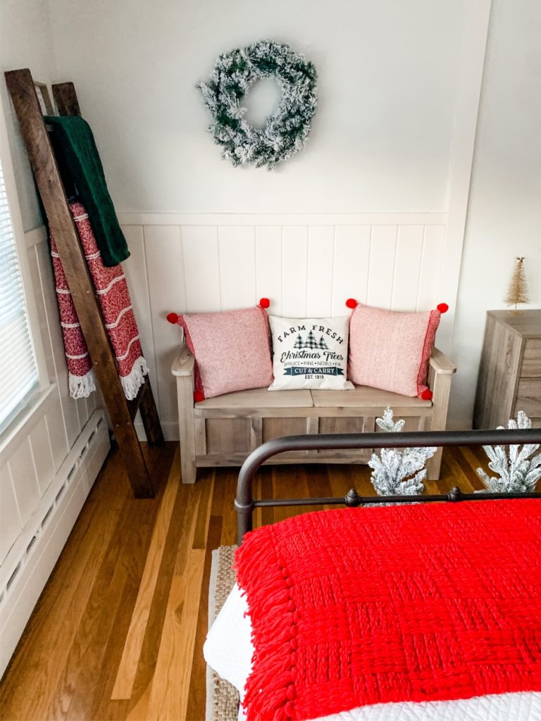 Christmas pillows and blankets on bench and blanket ladder