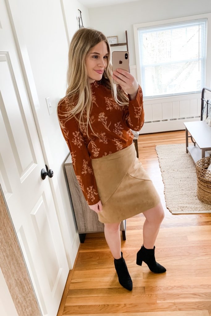 girl wearing long sleeve floral top with suede skirt