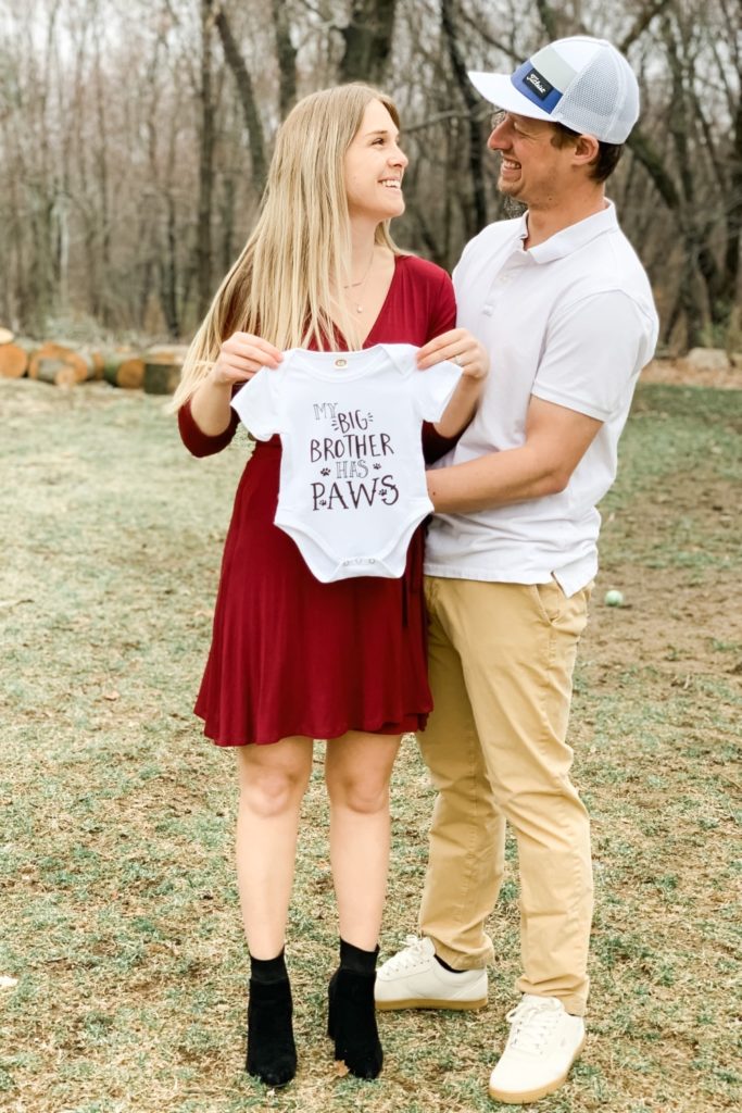 pregnancy announcement, couple holding baby onesie