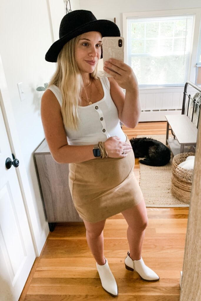 bump style: girl in White booties, suede tan skirt, white tank top with buttons and a black hat