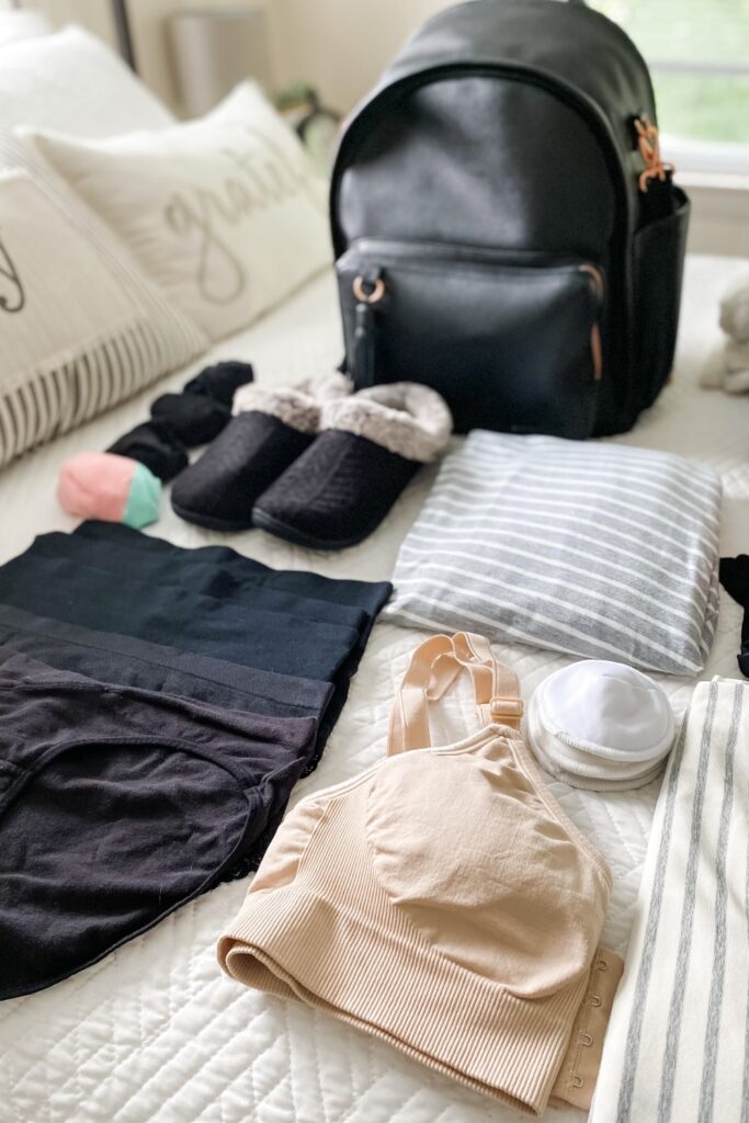 clothes laid out on bed to pack in hospital bag